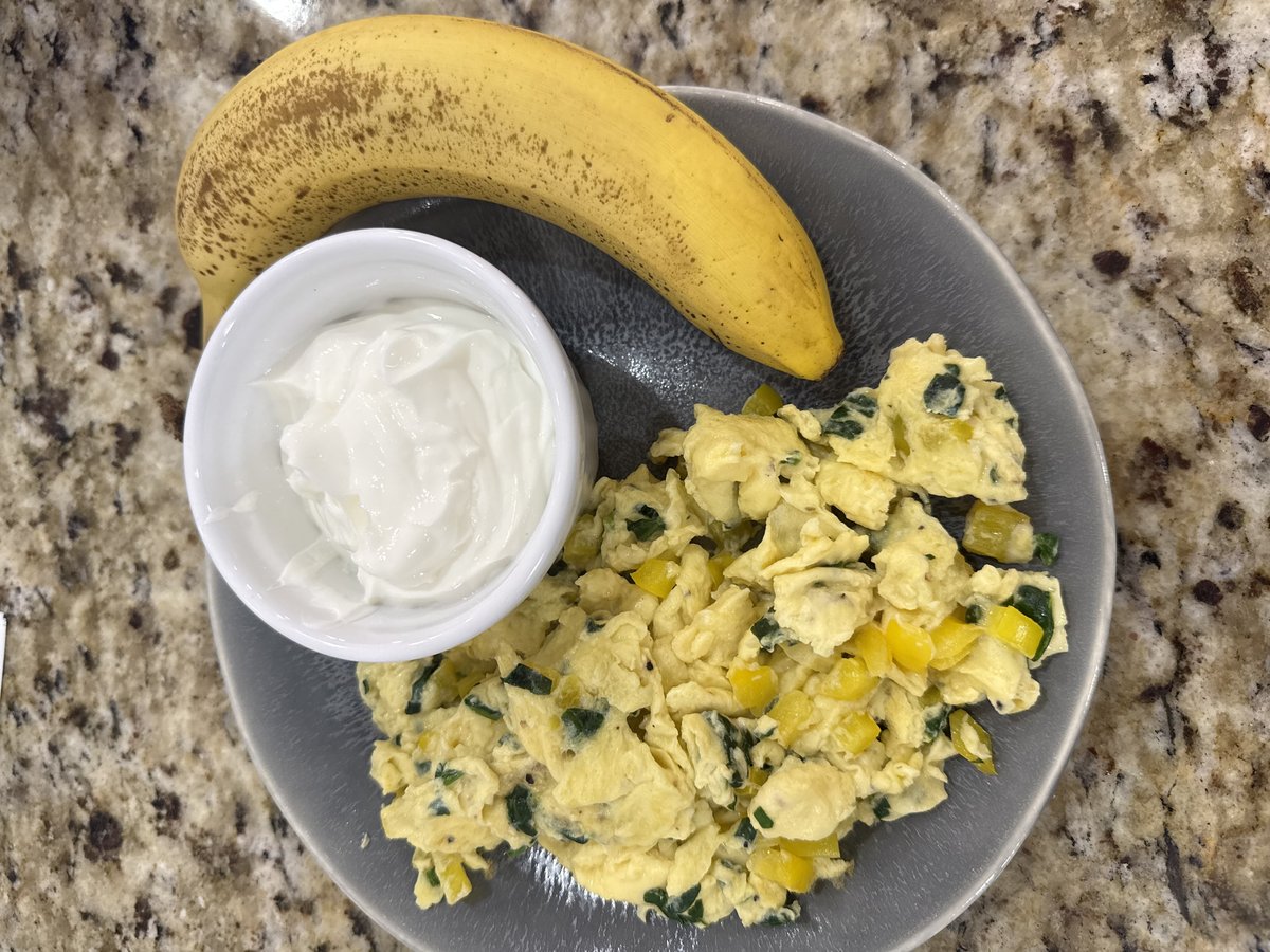 Breakfast plate: veggie scramble with spinach and yellow bell pepper, a cup of blended Greek yogurt, and a banana