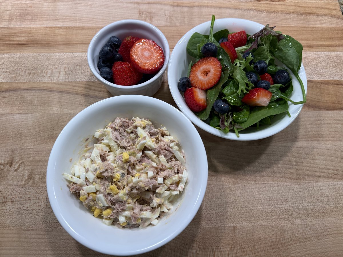 Lunch: bowl of tuna and egg salad, mixed greens salad topped with strawberries and blueberries, and a cup of berries